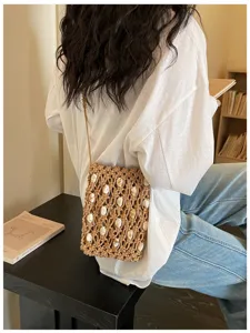 Detailed view of a bohemian woven phone bag with white marble beads on a female model