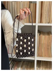 Detailed shot of a dark brown macrame phone bag embellished with white beads