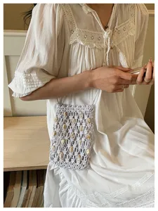 Asian model carrying a white macrame crossbody phone bag with beaded accents on summer vacation