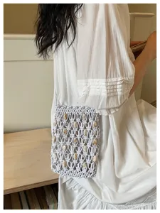 Detailed view of handmade beaded macrame mobile phone bag for beach vacation