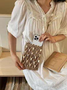 Handmade boho macrame woven phone bag with shell accents for seaside beach vacations
