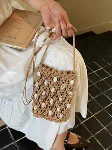 Bohemian macramé phone bag with shell beads, perfect for beach holidays and casual style.