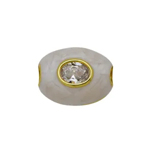 Perle d'espacement ovale en cuivre plaqué or avec texture marbrée blanche et zircon clair.
