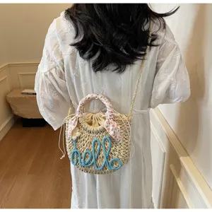 Detailed view of straw bucket bag with blue hello embroidery and floral scarf handle