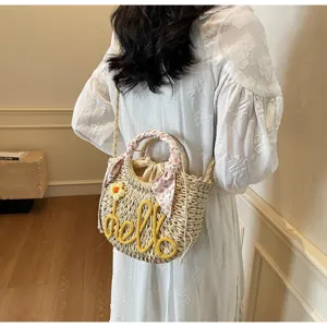 Handwoven straw bucket bag with 'hello' embroidery and a floral silk handle scarf for summer