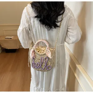 Detailed back view of model wearing a handmade straw bucket bag with floral scarf handle