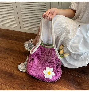 Close-up of purple hollow mesh tote bag with white flower charm and yellow tulips
