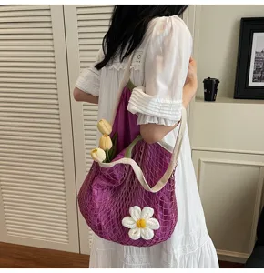 Lifestyle detail shot of a purple mesh hollow tote bag with white flower decoration.