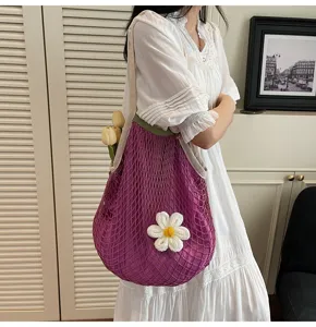 Elegant purple mesh crochet tote bag with white flower charm worn with white dress