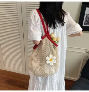 Close-up detail of a handmade mesh crochet tote bag featuring a white flower and tulips