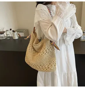 Detailansicht einer großen Strohtasche mit bunten Trägern am Modell