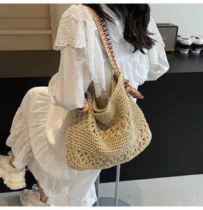 Detailansicht einer Bohème-Strohtasche mit Lochmuster und buntem Schultergurt