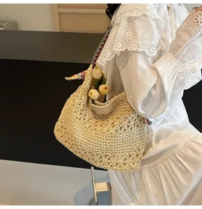 Detailansicht einer gewebten Stroh-Einkaufstasche mit Blumenmuster, von Model getragen