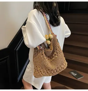 Detailansicht der ausgehöhlten Strohtasche mit bunt gewebtem Schultergurt