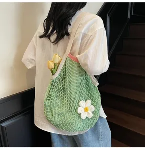 Green mesh tote bag with crochet daisy flower and yellow tulips shown on model