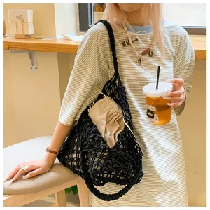 Minimalist black woven net tote bag with drawstring inner pouch shown in lifestyle detail