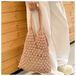 Detail view of a pink cotton rope woven hollow-out tote bag with drawstring inner pouch.