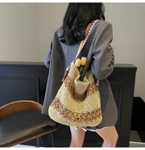 Detailansicht einer böhmischen gewebten Stroh-Tote-Bag mit buntem Riemen am Model