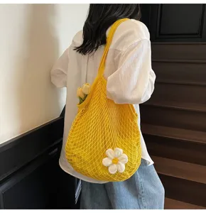 Macro view of the yellow summer hollow mesh tote bag with a white crochet flower
