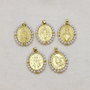 Detalle de cinco colgantes religiosos ovales bañados en oro 18k con borde de perlas