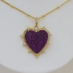 Close-up detail of 18k gold plated brass heart necklace with purple zircon stones.