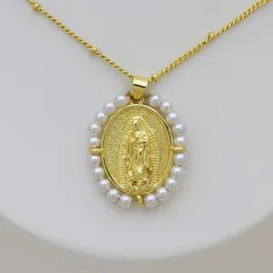 Detalle del colgante ovalado Virgen de Guadalupe en latón chapado en oro 18k con borde de perlas.