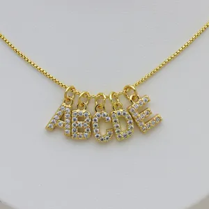 Gedetailleerde close-up van de vergulde ketting met schitterende zirkonia letterhangers.