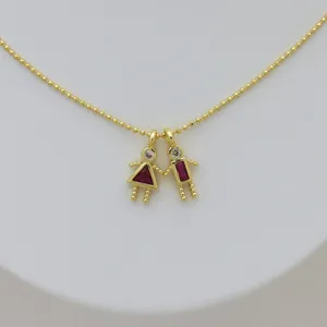 Close-up of 18K gold-plated boy and girl pendant with red and clear zircons on ball chain.