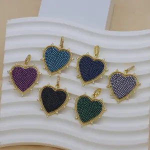 Close-up of heart-shaped pendants with colorful micro-pave CZ stones on a white background.