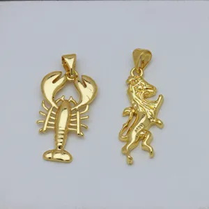 Close-up detail of 18K gold plated lobster and lion animal pendants on white surface.