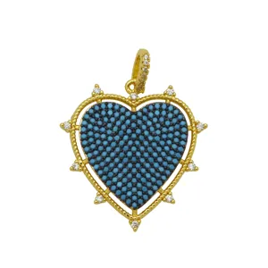 Detailed close-up of a gold-plated heart pendant featuring turquoise beads and zircon stones