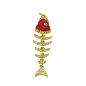 Detalle de un colgante de espina de pescado bañado en oro 18K con esmalte rojo y circón