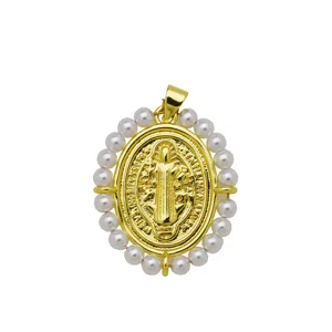 Detalle de colgante medalla religiosa ovalada bañada en oro 18k con borde de perlas