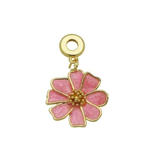 Macro detail of a pink enamel flower pendant with 18K gold-plated trim and center