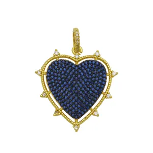 Close-up detail of heart shaped pendant with blue cubic zirconia stones in 18k gold plating