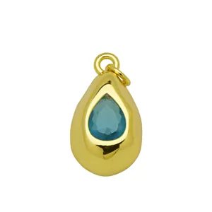 Gros plan d'un pendentif goutte plaqué or orné d'un zircon bleu facetté brillant