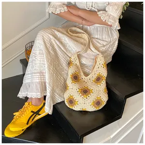 Handmade crochet cotton bag with yellow sunflower motifs in a lifestyle setting