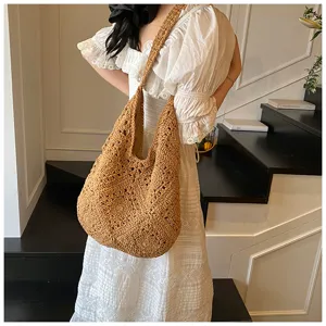 Handmade crochet hobo bag with sunflower pattern shown on model's shoulder