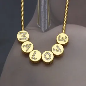 Close-up of gold round pendants with crystal letters spelling LOVE on a snake chain