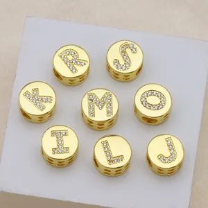 Macro view of gold round alphabet beads featuring rhinestone-inlaid letters for DIY jewelry