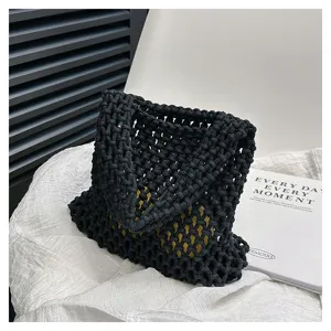 Schwarze hohle gewebte Baumwollseiltasche Detailaufnahme, handgemachte Textur Handtasche.