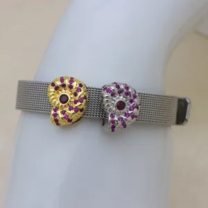 Gros plan du bracelet en maille avec deux pendentifs coquillage, zircons roses et pierre.