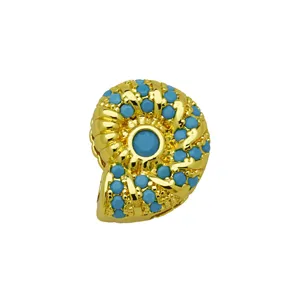 Vue de détail de breloque coquillage zircon turquoise, accessoire de bracelet style océan doré.