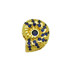 Gros plan détail de pendentif bijoux coquillage or zircon bleu pour bracelet montre.