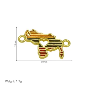 Close-up of golden metal map charm connector with heart cutout, DIY jewelry accessory detail.
