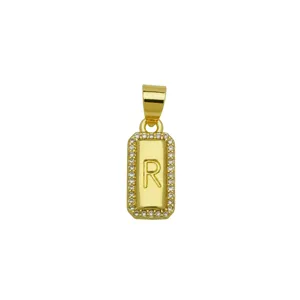 Detail showing the engraved letter R and sparkling zircon border on a gold pendant.