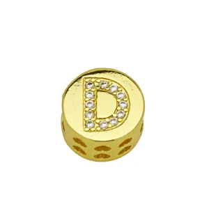 Detail shot of a gold-plated circular charm featuring a crystal-studded letter D.