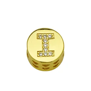 Detailed view of gold-tone round charm featuring rhinestone letter I for DIY jewelry.