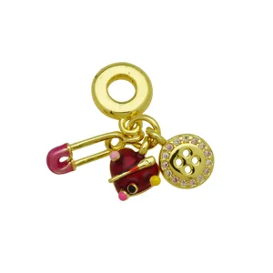 Vergoldetes Charm-Detail mit Sicherheitsnadel, rotem Herz und glitzerndem Strass-Knopf.