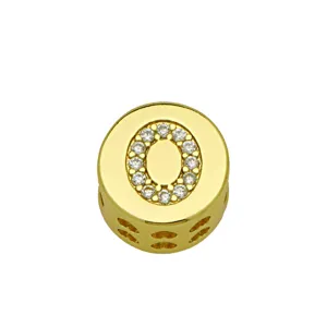Close-up of golden letter O charm pendant with shimmering pavé crystal details